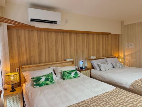 a hotel room with two beds with green pillows at TOKYO SKYTREE VILLIA-Whole villia space perfect for families and groups in Tokyo