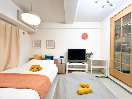 two beds in a small room with a tv at Stylish ROCO house Omori8min in Tokyo