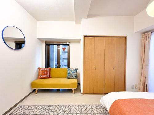 a bedroom with a yellow chair and a mirror at Stylish ROCO house Omori8min in Tokyo