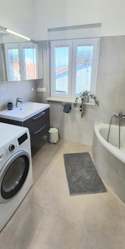 a bathroom with a washing machine and a bath tub at SkyAdria Penthouse in Vir