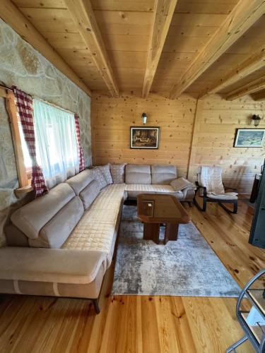 a living room with a couch in a log cabin at Vacation Home Andjelic in Žabljak