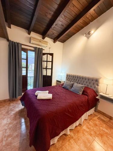 a bedroom with a large bed with a red blanket at KAKAN - Dpto 2 dormit- Primer piso in Cafayate