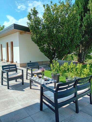 three benches and a table on a patio at Apartma - Hiša Zofija in Slovenske Konjice