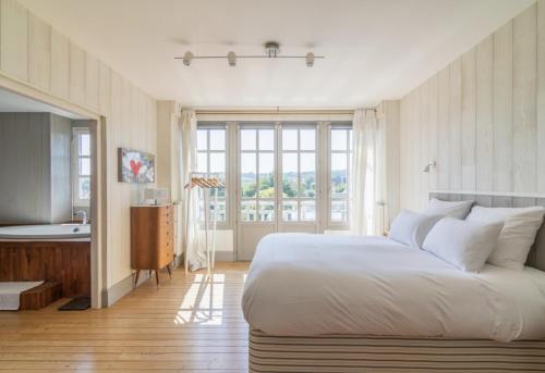 une chambre avec un grand lit et une salle de bain dans l'établissement Beautiful historic villa close to Deauville, à Villers-sur-Mer