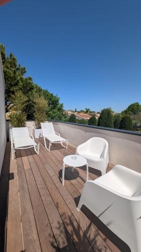 a group of white chairs and tables on a roof at Le relais d'Angélique in Lunel