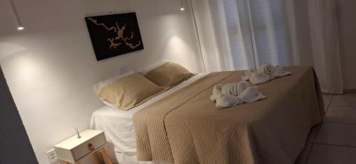 a bedroom with a bed with towels on it at Aquavit pousada e comedoria in Jacumã