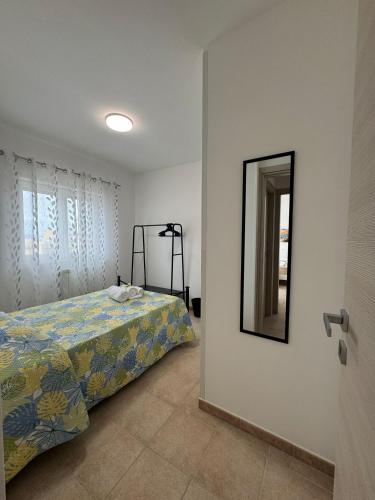 a bedroom with a bed and a mirror on the wall at A casa di Lorenza in Taranto