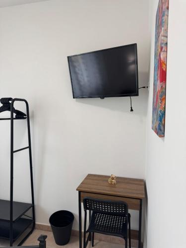 a room with a table and a television on a wall at A casa di Lorenza in Taranto