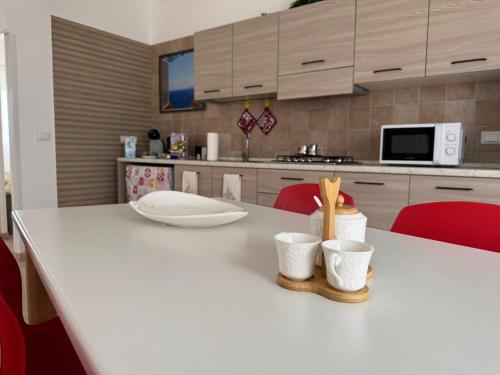 a kitchen with a white table with two cups on it at A casa di Lorenza in Taranto