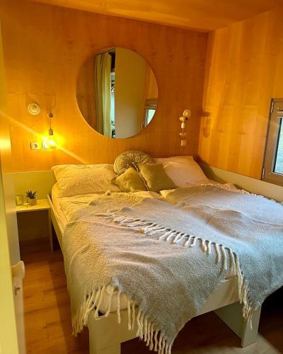 a bedroom with a bed with a mirror on the wall at VRBA mobile house by the Kolpa river BIG BERRY Metlika in Metlika