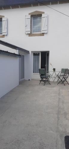 a white building with two chairs and a window at Ty Guen in Audierne
