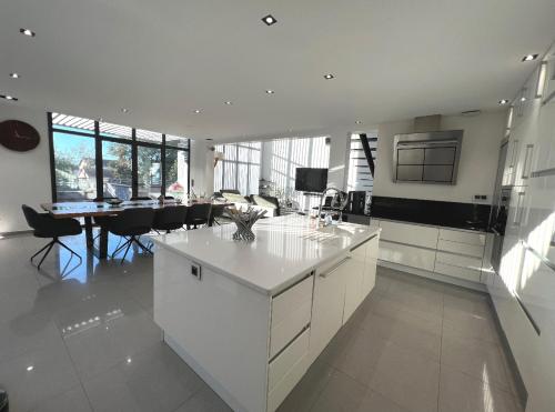 une cuisine avec des placards blancs et une salle à manger dans l'établissement Loft Atypique Beaucaire, à Beaucaire