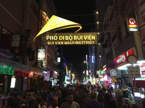 ホーチミン・シティにあるThe Pearl of the Far Eastの夜の賑やかな街並みを歩く人々