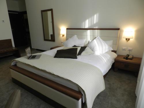 a bedroom with a large bed with white sheets and pillows at Boutique Hotel Kotoni in Tirana