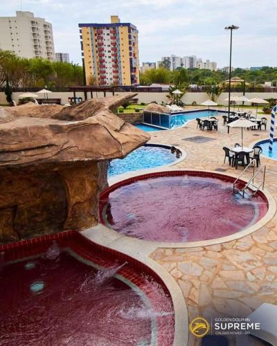a large pool of purple water in a courtyard at Golden Dolphin Grand Hotel piscinas 24 hs MP in Caldas Novas