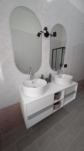 a bathroom with two sinks and a large mirror at Appartamento in residence "CASA DAMIA" in Taranto