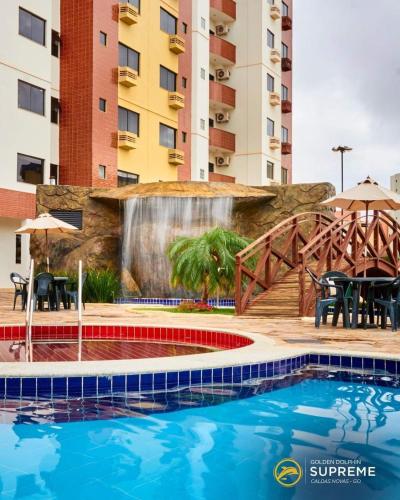 a swimming pool with a fountain in front of a building at Golden Dolphin Grand Hotel piscinas 24 hs MP in Caldas Novas