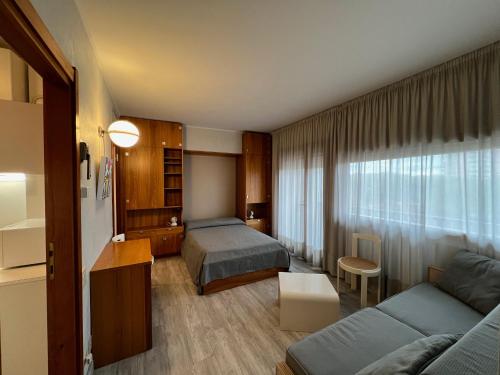 een hotelkamer met een bed en een bank bij Euro Residence in Lignano Sabbiadoro