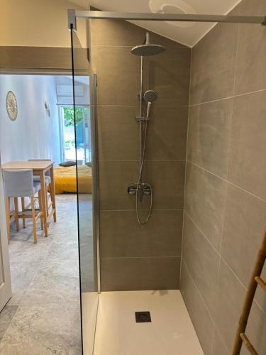 une douche avec une porte vitrée dans une salle de bain dans l'établissement Studio L'Essentiel, à Istres