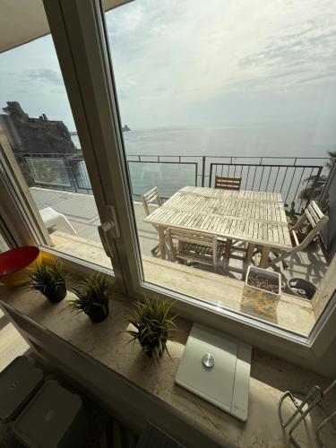 a balcony with a table and a view of the ocean at Casa Vitale in Aci Castello