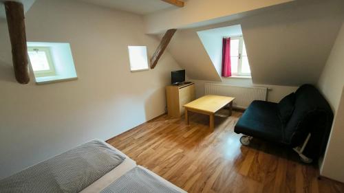 a room with a bed and a chair and a desk at Penzion U Houšků in Stráž nad Nežárkou
