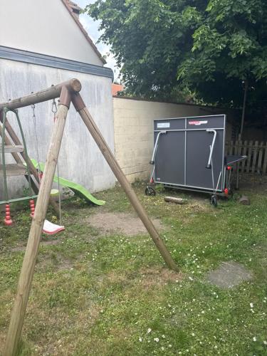 un grand cadre en bois dans une cour avec une table de ping-pong dans l'établissement Studio au calme dans jardin à 30min de Paris avec NOUVELLE LITERIE, à Chatou