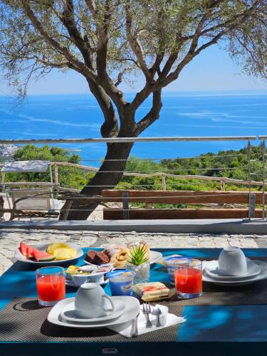 a table with food and a view of the ocean at Hotel Pranos Turismo Rurale Cala Gonone in Cala Gonone