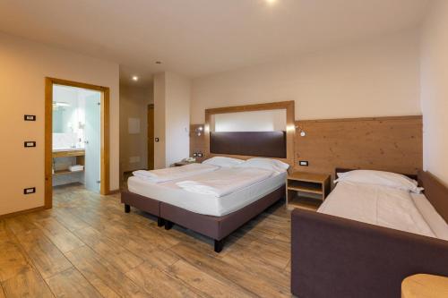 a bedroom with two beds and a mirror at Park Hotel Avisio in Soraga