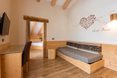 a room with a bed and a desk and a television at Park Hotel Avisio in Soraga