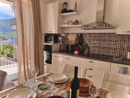 a kitchen with a table with a bottle of wine at The Legendary Apartment in Dobrota
