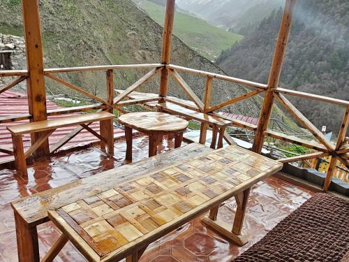 a room with a table and benches on top of a mountain at MURQVAMI Guesthouse in Adishi
