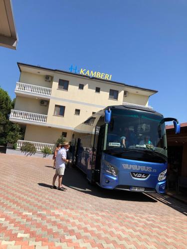 a blue bus parked in front of a building at Kamberi Hotel & Apartments in Velipojë