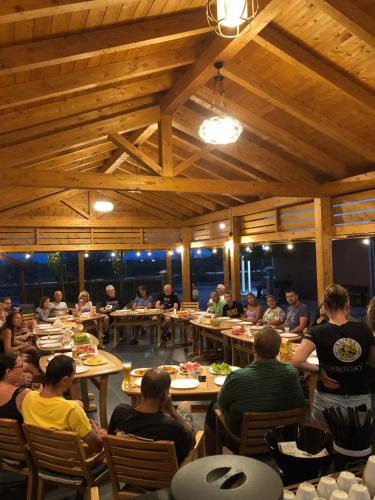 a group of people sitting at tables in a restaurant at Kamberi Hotel & Apartments in Velipojë