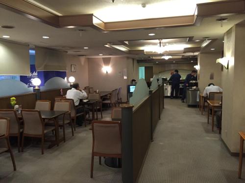 a dining room with people sitting at tables in a restaurant at Hotel Crown Hills Kitami in Kitami