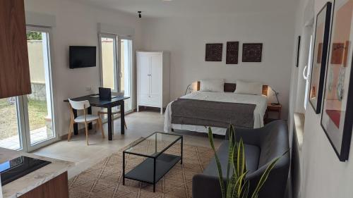 a bedroom with a bed and a table and a desk at 2-Person Studio, Private Splash Pool, 5 Min Beach in Novo Sancti Petri