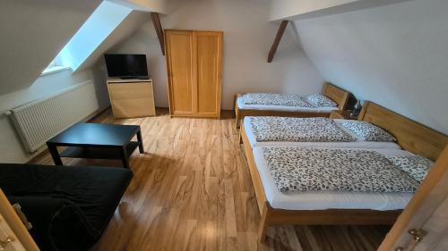 a room with three beds and a television in it at Penzion U Houšků in Stráž nad Nežárkou