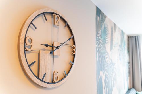 a clock hanging on a wall next to a window at REMZ Apartments & Wellness in Dorog