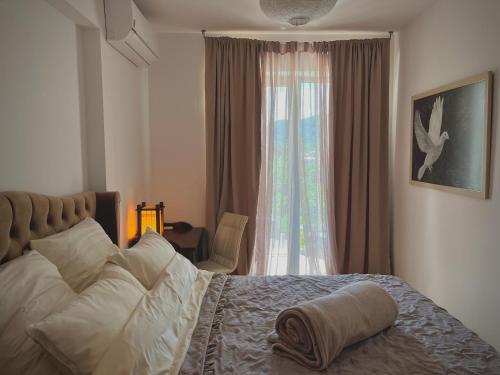 a bedroom with a large bed and a window at The Legendary Apartment in Dobrota