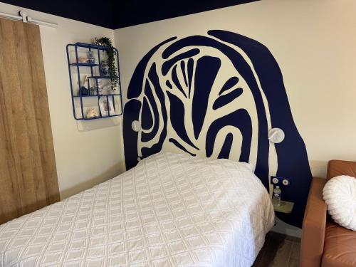 a bedroom with a bed with a black and white headboard at Studio indépendant proche aeroport Nantes in Saint-Aignan-Grand-Lieu