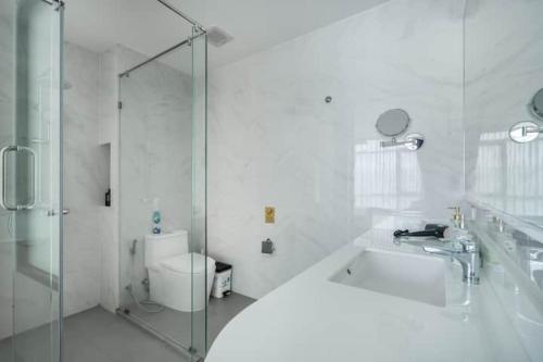 a bathroom with a shower and a sink and a toilet at Modern 1506 Condo in Wyndham Gardens on the beach in Nai Thon Beach