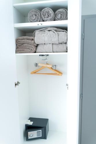 a shelf with towels and a scale in a closet at REMZ Apartments & Wellness in Dorog