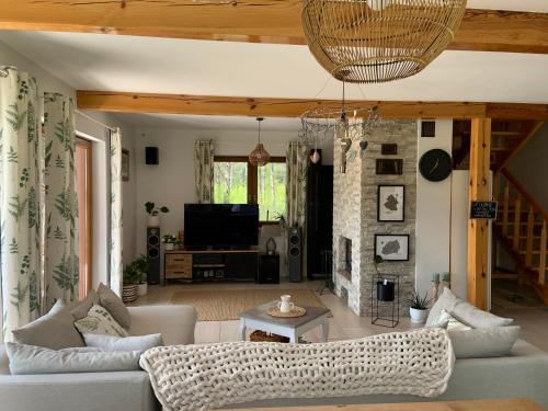 a living room with a couch and a tv at Lavender Cottage in Sucha Rzeczka