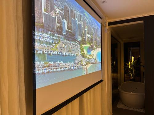 a projection screen on a wall in a hotel room at Exclusive Cabanas in Serra Negra