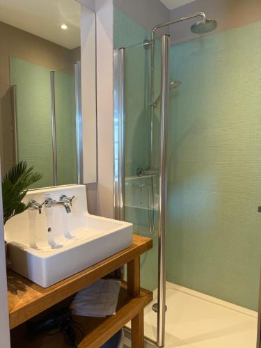a bathroom with a sink and a glass shower at Maison familiale et cosy à la mer in Saint-Valery-sur-Somme