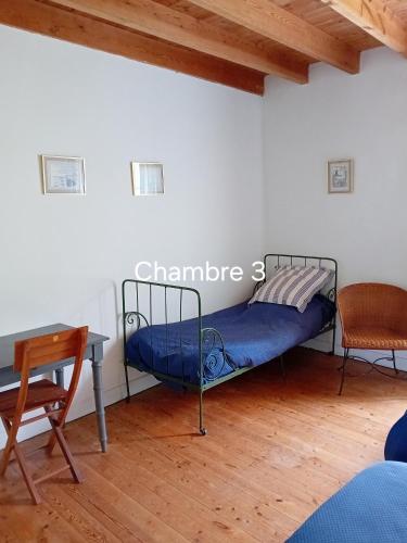 une chambre avec un lit, une table et un bureau dans l'établissement Gîte de La Ferme de La Cour, à Crasville