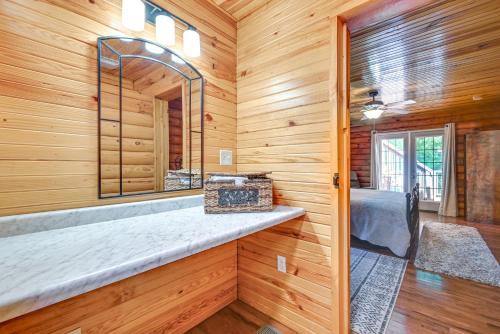 a bathroom with a mirror in a wooden wall at Woodsy Kentucky Escape with Game Room and Lake Access! in Burnside