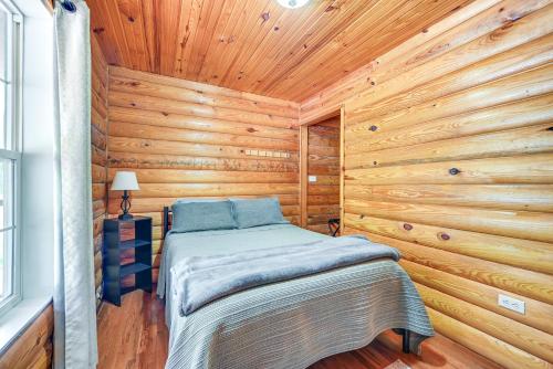 a bedroom with a bed in a wooden cabin at Woodsy Kentucky Escape with Game Room and Lake Access! in Burnside