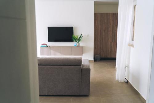 a living room with a couch and a flat screen tv at The Valley Collection - Suite A21 in Xagħra