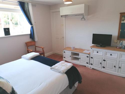 a bedroom with a bed and a television in it at The Evenhill in Canterbury