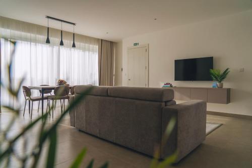 a living room with a couch and a table at The Valley Collection - Suite A21 in Xagħra